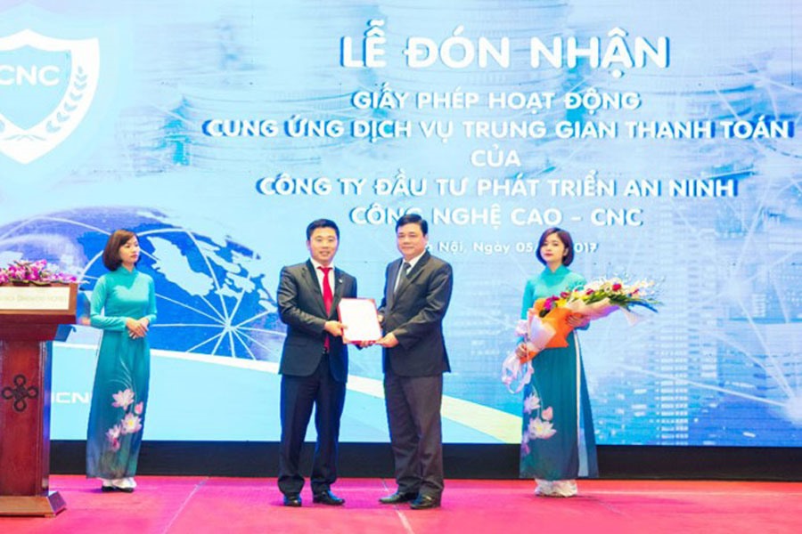 Đại diện CNC là Nguyễn Văn Dương (trái) nhận giấy phép từ đại diện NHNN tháng 4.2017. Ảnh: P.V