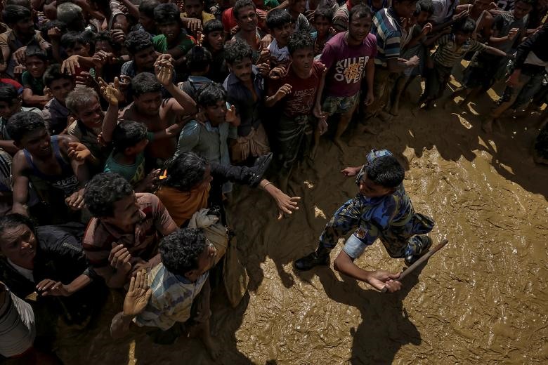 Một nhân viên an ninh nỗ lực kiểm soát những người tị nạn Rohingya đang chờ đợi để nhận sự viện trợ ở Cox's Bazar, Bangladesh, ngày 21/09/2017. (Ảnh: Reuters)