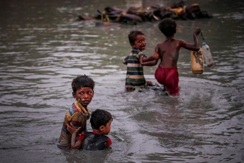 Những cặp anh em người Rohingya giữ chặt lấy nhau trong lúc chạy trốn khỏi bạo lực khi băng qua con sông Naf dọc theo biên giới Bangladesh – Myanmar ở Palong Khali, gần Cox's Bazar, Bangladesh , ngày 01/11/2017. (Ảnh: Reuters)