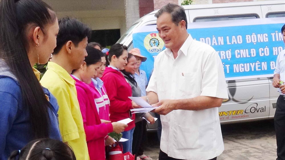 Chủ tịch LĐLĐ tỉnh Bình Phước (bìa phải) đang phát quà cho CNLĐ. Ảnh: BP.