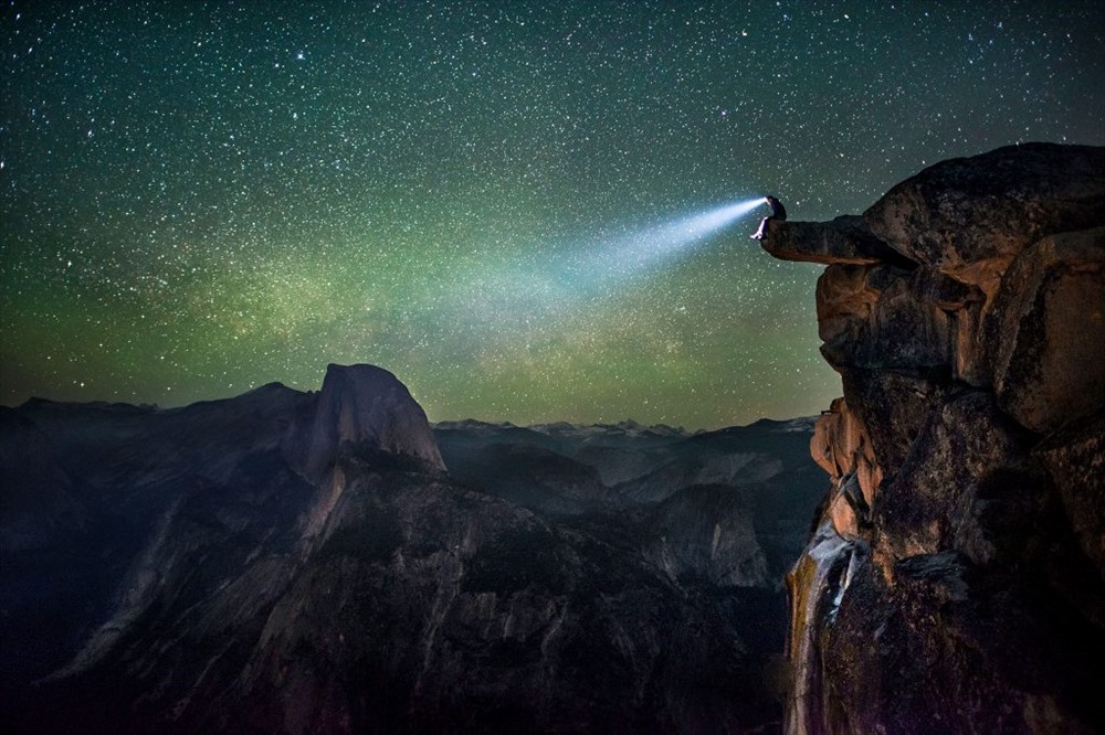 Một người đàn ông lạ mặt trong một đèn pha ở rìa Glacier Point ở Yosemite nhìn chằm chằm vào khung cảnh đáng kinh ngạc