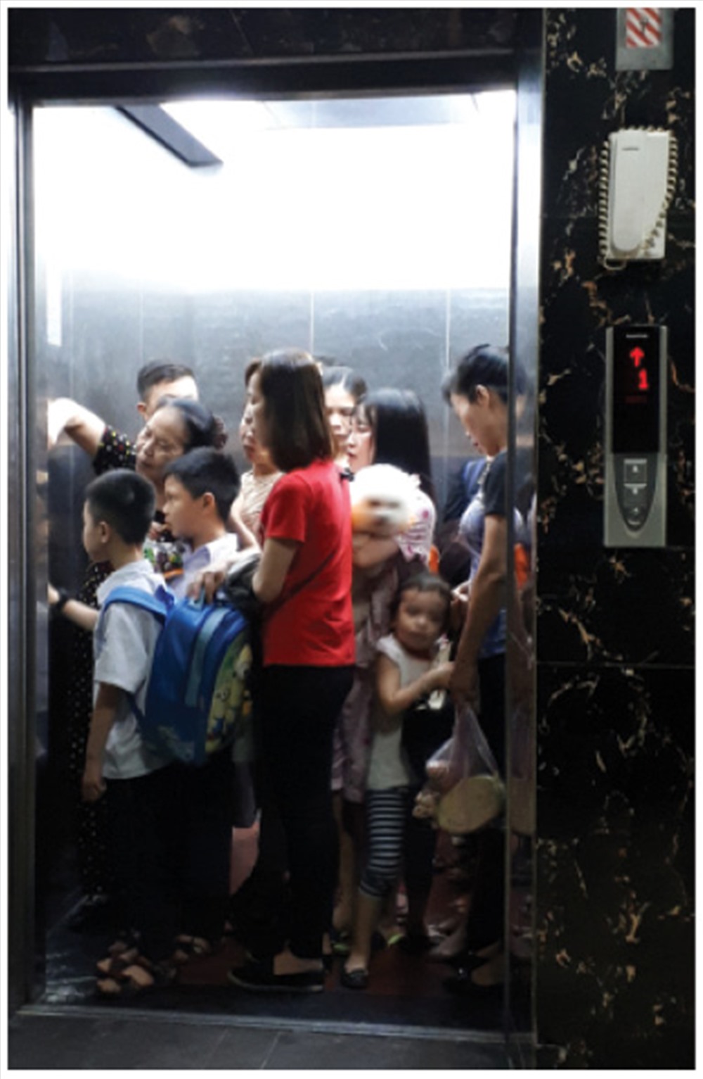 Cảnh người dân chen chúc vào thang máy. 