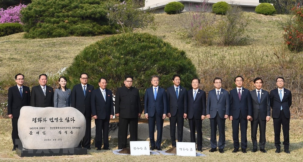 Hai nhà lãnh đạo cùng các quan chức cấp cao hai nước chụp ảnh lưu niệm sau khi trồng cây thông hòa bình. Ảnh: TTXVN