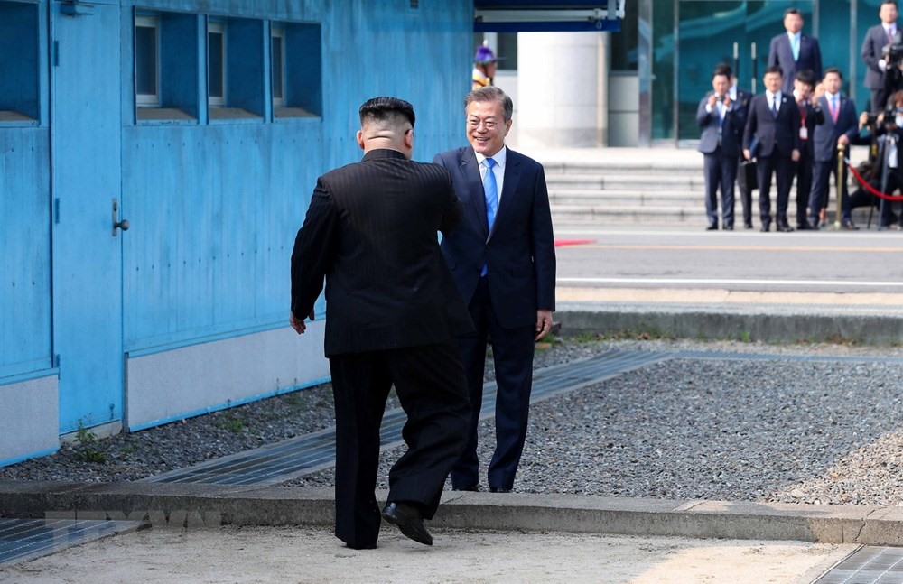 Tổng thống Hàn Quốc Moon Jae In đón Nhà lãnh đạo Triều Tiên Kim Jong Un tại ranh giới phân định giữa hai miền Bắc - Nam bán đảo Triều Tiên. Ảnh: TTXVN