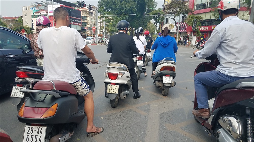 Tại một số nút giao thông tại Hà Nội, tình trạng không đội mũ bảo hiểm, đèo 3 người quá quy định vẫn diễn ra.