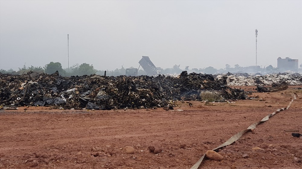 Hàng nghìn tấn nguyên liệu dệt sợi bị cháy đã trở thành rác được tập kết tạm ra một bãi đất trống để phân loại xử lý. Ảnh: T.N.D