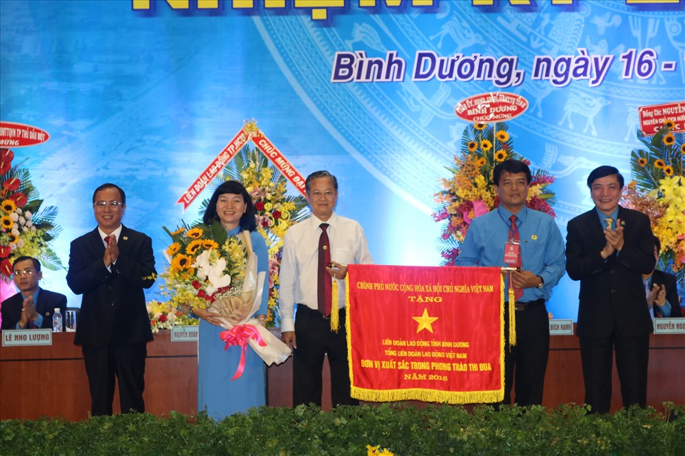 Chủ tịch Tổng LĐLĐ Việt Nam Bùi Văn Cường (phải ảnh) và Bí thư tỉnh ủy Trần Văn Nam (trái ảnh) trao cờ thi đua xuất sắc của Thủ tướng Chính phủ cho LĐLĐ tỉnh Bình Dương
