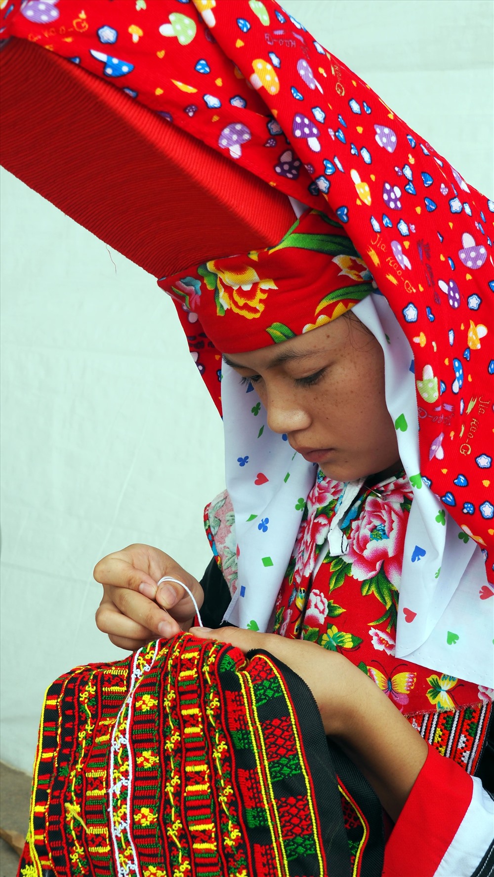 Một cô thôn nữ dân tộc Dao Thanh Phán đang chăm chút đường kim, mũi chỉ.
