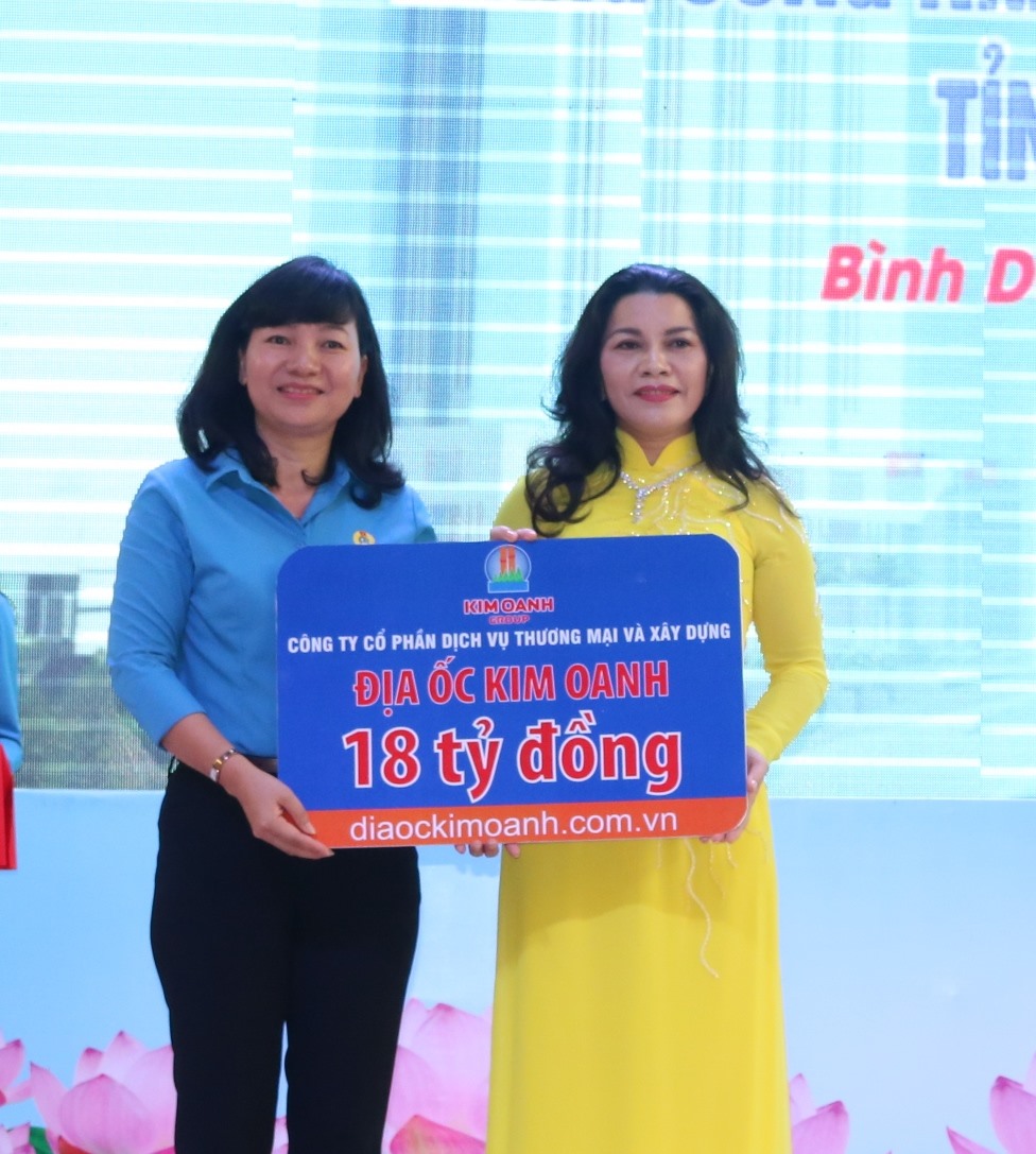 Bà Đặng Thị Kim Oanh (phải ảnh) - Tổng giám đốc CP DVTM & XD Địa ốc Kim Oanh trao biểu trưng tặng 18 tỷ đồng xây dựng Nhà trẻ 28/7 (giai đoạn 2) cho LĐLĐ tỉnh Bình Dương