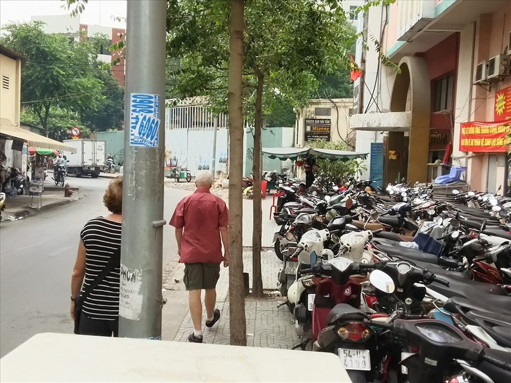 Người nước ngoài đi sát ra mép vỉa hè đường Huỳnh Thúc Kháng vì bên trong bị chiếm làm bải giữ xe máy