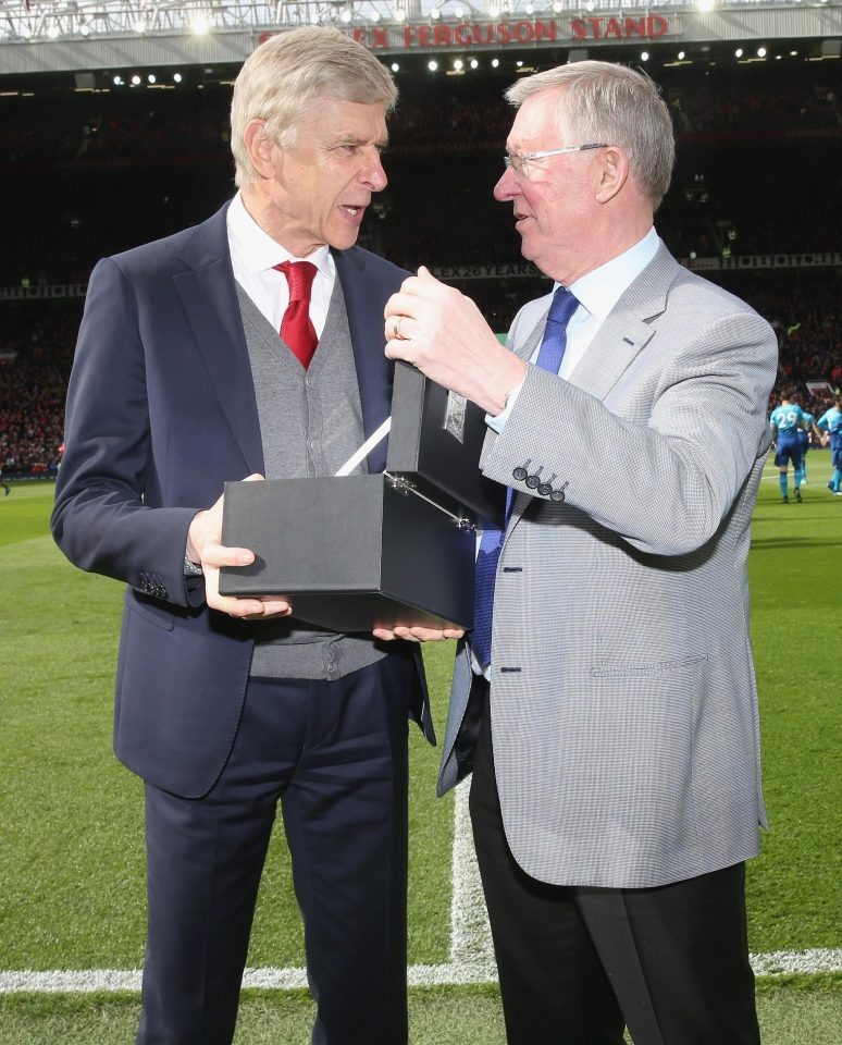 Sir Alex tươi cười bên Arsene Wenger khi trao kỉ niệm chương tại sân Old Trafford. Ảnh: Getty.