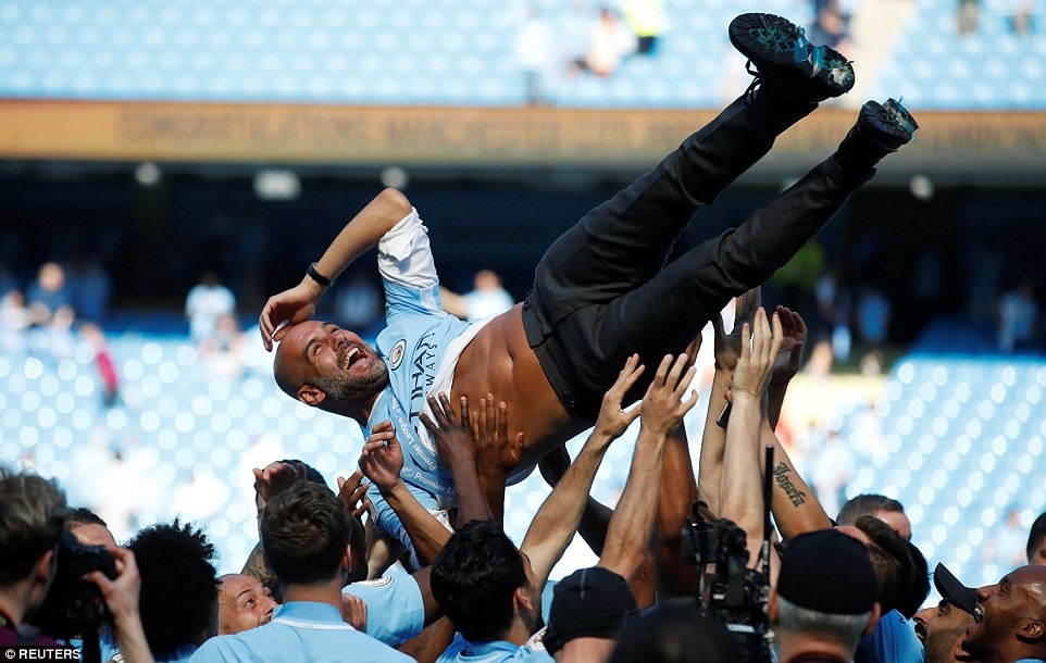 HLV Pep Guardiola tận hưởng niềm hạnh phúc trong lần đầu vô địch Premier League. Ảnh: Reuters.