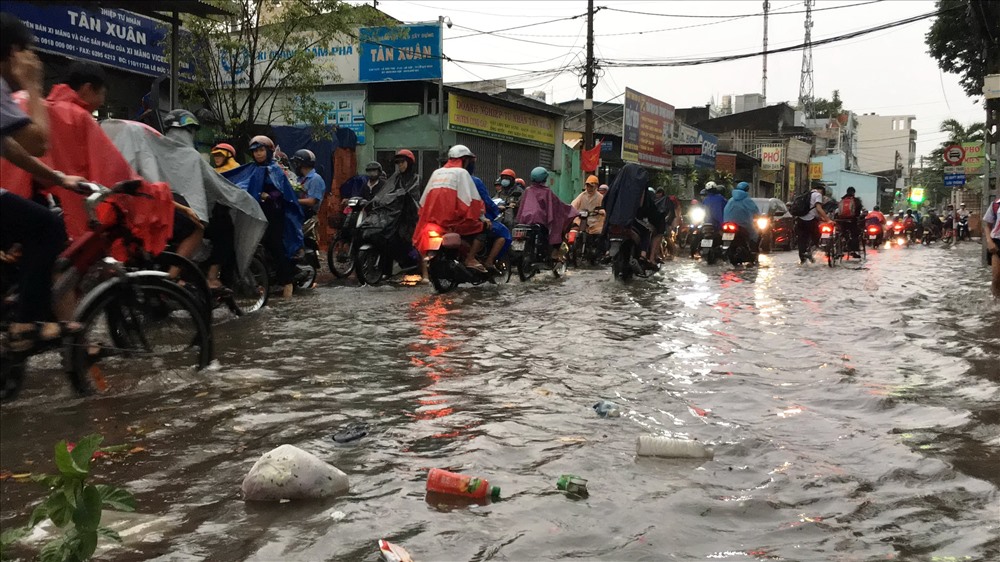 Nước ngập đường Lê Văn Thọ (quận Gò Vấp) kèm theo nhiều rác thải, bốc mùi hôi tanh.