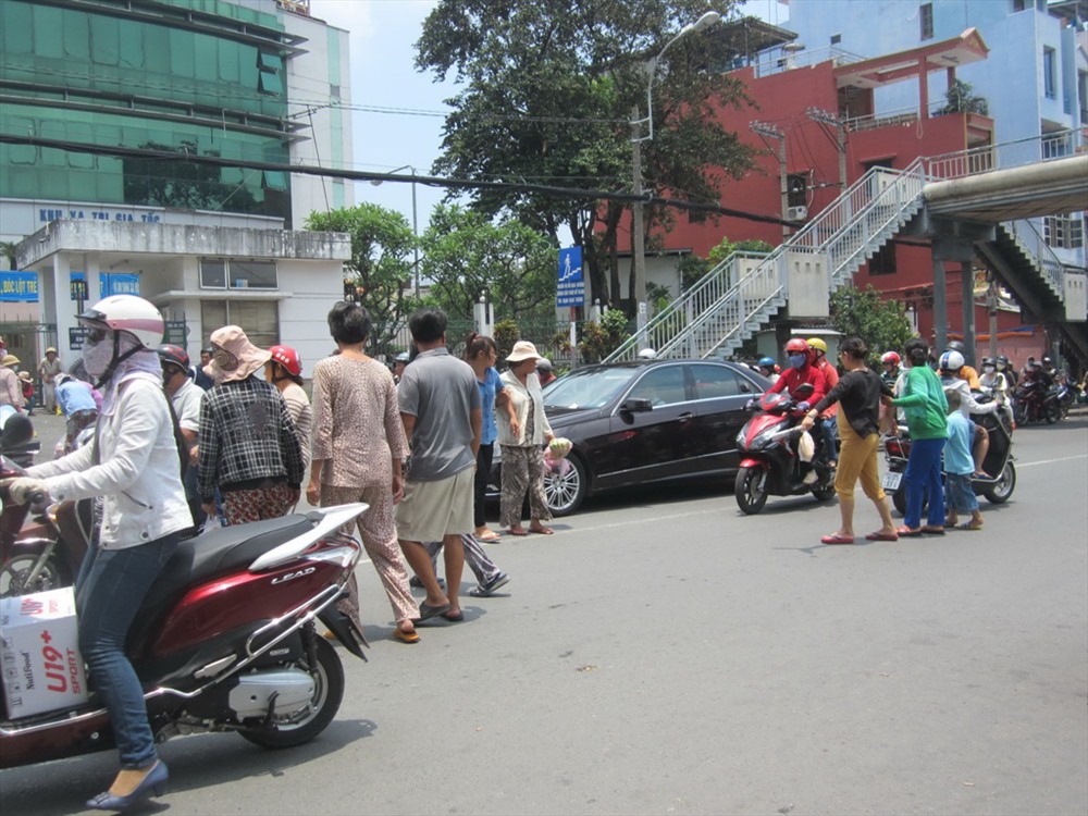 Người dân vẫn băng qua đường thay vì đi lên cầu bộ hành, bất chấp dòng xe cộ đông đúc qua lại.