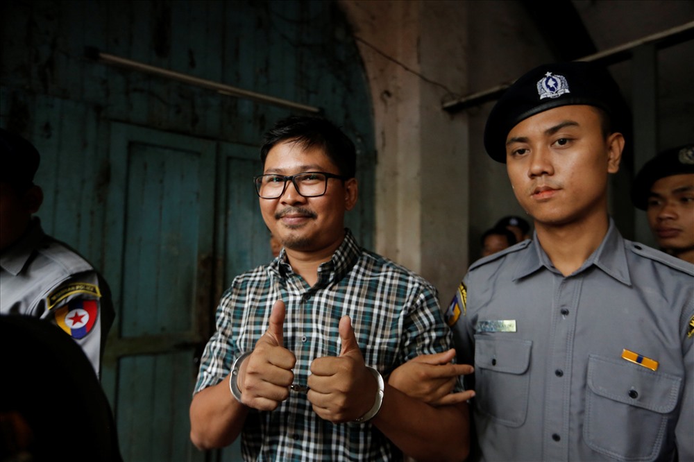 5.	Nhà báo Reuters đã bị cảnh sát Wa Lone hộ tống ra khỏi phiên tòa tại Yangon, Myanmar, ngày 12 tháng 6 năm 2018 . 2 phóng viên Reuters bị bắt tại Myanmar, những người bị buộc tội sở hữu những tài liệu mật của chính phủ.