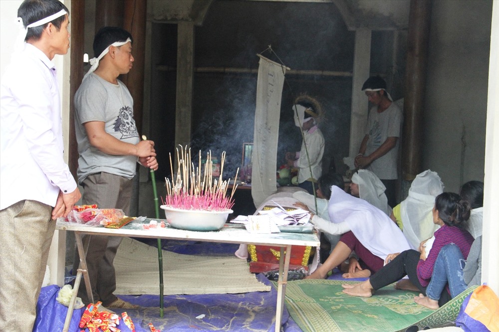 Người nhà nạn nhân Quân làm lễ an táng trong căn nhà xây dở dang. Ảnh:CH