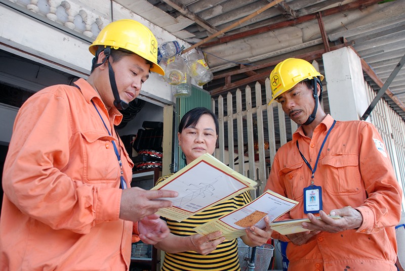 Phát tờ rơi tuyên truyền đến các hộ dân sinh sống gần đường dây và trạm điện  Ảnh: Hoa Việt Cường