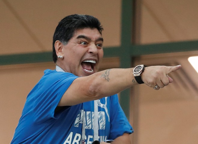 Là khách mời của FIFA với vai trò đại sứ, những “cậu bé vàng” Maradona lại liên tục diễn những trò lố trên các khán đài tại World Cup trên đất Nga. Ảnh: FIFA
