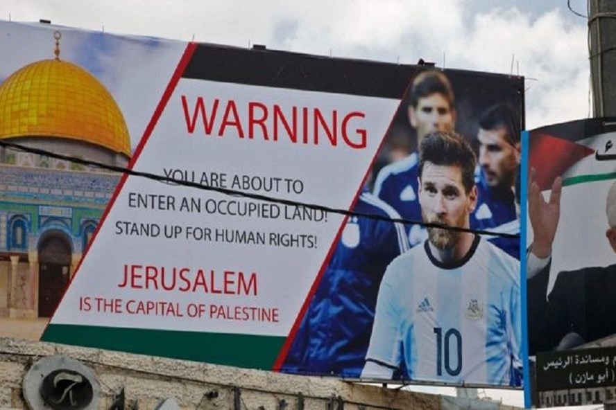 “Cảnh báo Messi! Cậu đang bước vào một vùng đất bị chiếm đóng. Hãy đứng lên vì quyền con người đi. Jerlusalem là thủ đô của Palestine“. Ảnh: Reuters.