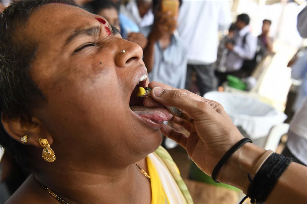 Một bệnh nhân nhận thuốc trong miệng của một con cá murrel sống. Công thức thảo dược được yêu cầu để chữa bệnh hen suyễn và các rối loạn hô hấp khác