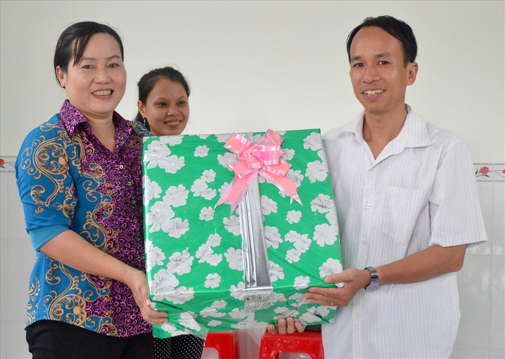 Bà Nguyễn Kim Huyền - Chủ tịch LĐLĐ huyện Lấp Vò tặng quà cho gia đình anh Trần Hoàng Anh. (Ảnh: Lục Tùng)