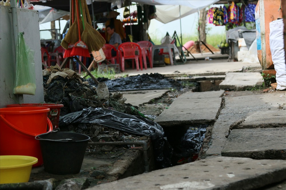 Người dân nạo vét rác ở một số ống cống. Cảnh ôi nhiễm, mất mỹ quan luôn luôn thường trực xuất hiện ở chợ. ảnh: Bảo Trung