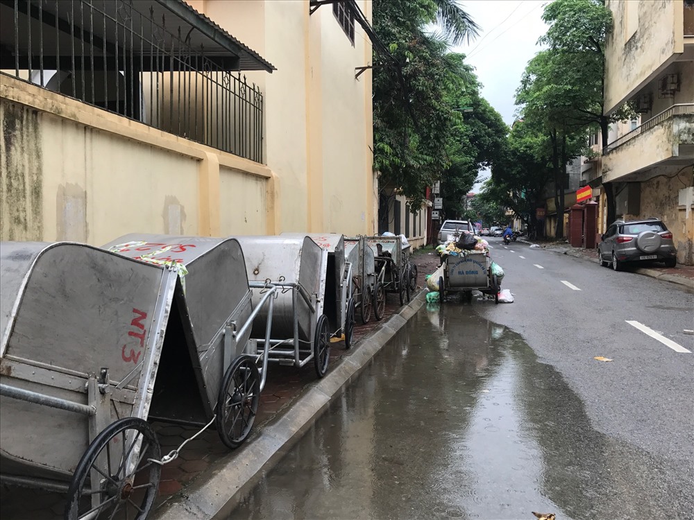 Hàng chục xe vận chuyển rác nằm chờ... công nhân trên một ngõ của phố Tô Hiệu.