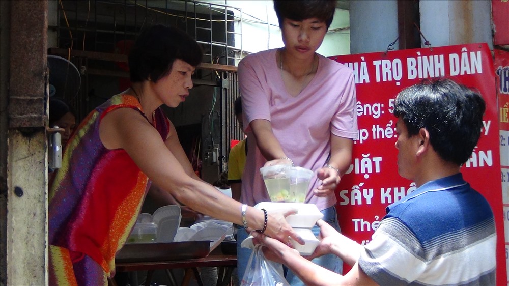 Cô Nguyễn Kim Loan (chủ địa điểm) phụ giúp nhóm Cơm Tự Tâm giao phần cơm cho người nhà bệnh nhân