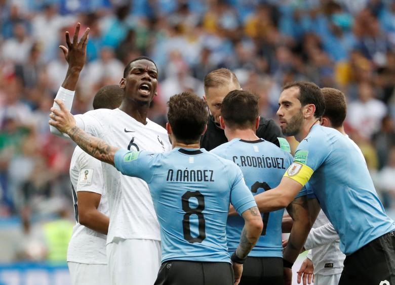 Các cầu thủ Uruguay nổi điên với trò ăn vạ của Mbappe. Ảnh: Reuters