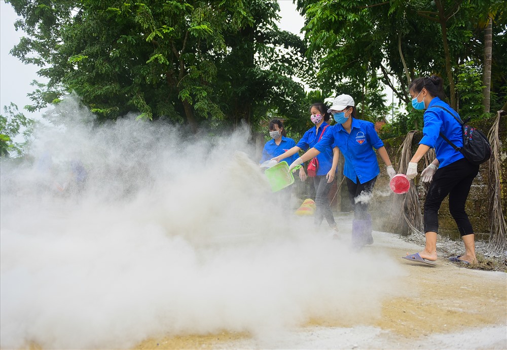 Tại xã Tân Tiến (huyện Chương Mỹ, TP Hà Nội) hàng trăm tình nguyện viên đang tiến hành khử khuẩn, rắc vôi bột.