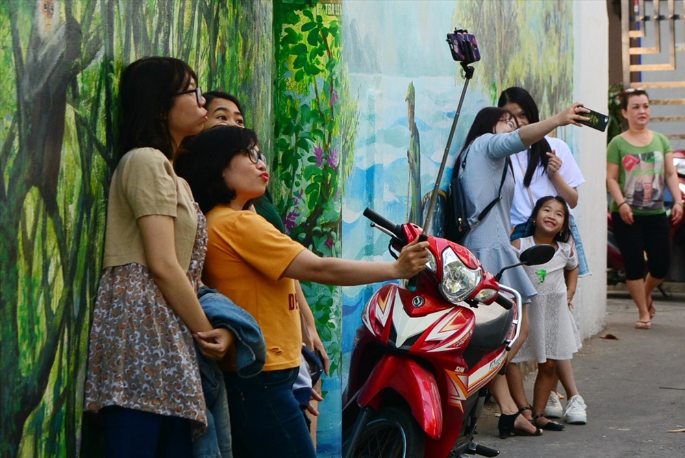 Khách ghé thăm và chụp ảnh tại hẻm bích họa Đà Nẵng trong những ngày đầu mở cửa. Ảnh: Việt Nam mới