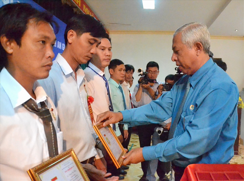 Chủ tịch LĐLĐ An Giang Nguyễn Thiện Phí trao Kỷ niệm chương CĐ cho đoàn viên. Ảnh: Lục Tùng. 