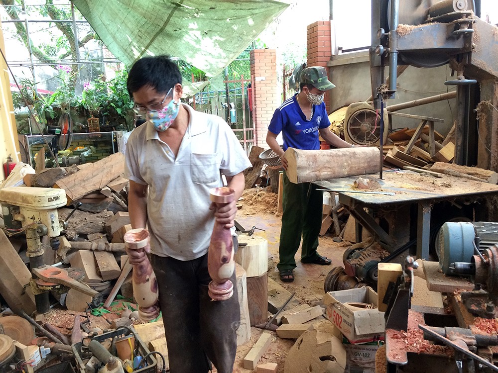 Hai bố con anh Trung đang làm việc trong xưởng mộc tại nhà.