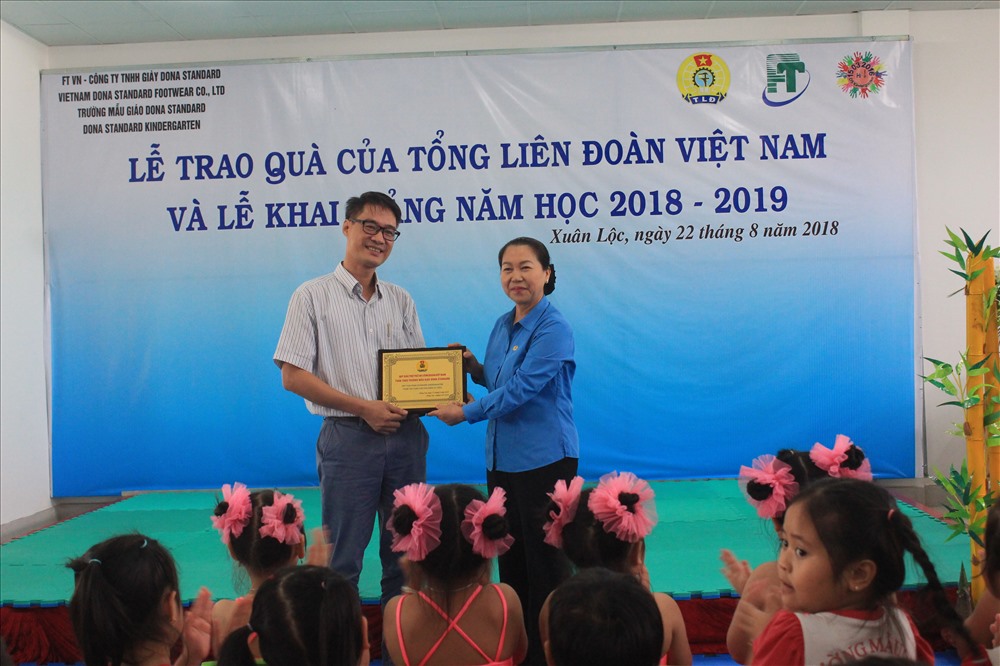 Lãnh đạo tập đoàn Phong Thái (trái) nhận món quà từ lãnh đạo Tổng LĐLĐVN là bộ đồ chơi ngoài trời cho con công nhân