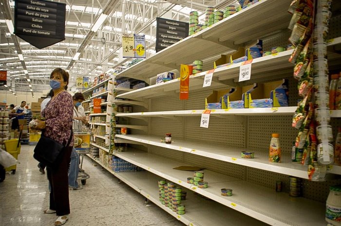 Hầu hết các kệ hàng trong siêu thị đều trong tình trạng trống trơn. 