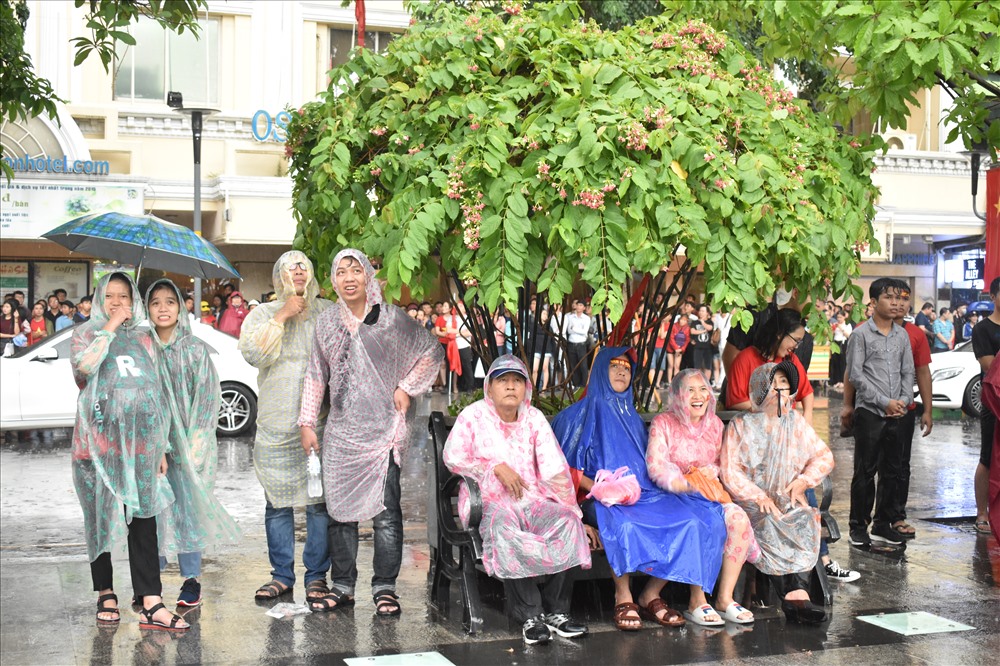 Không có áo mưa, nhiều người đã đứng trú dưới những tán cây để tiếp tục theo dõi trận bóng