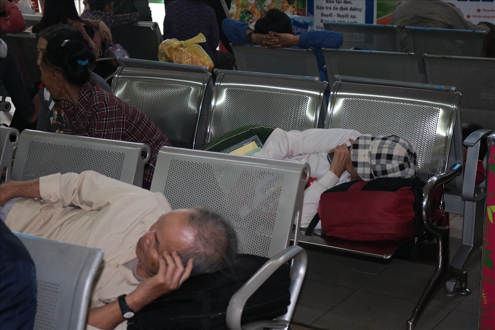 Nhiều hành khách chờ đợi mua vé lâu nên mệt mỏi và nằm nghĩ.