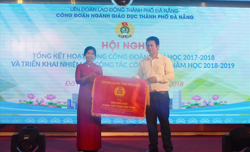 Trưởng Ban Tổ chức LĐLĐ TP Đà Nẵng Nguyễn Thành Hùng (bên phải) đại điện cho LĐLĐ TP trao cờ thi đua cho tập thể đã có thành tích xuất sắc trong hoạt động CĐ. Ảnh: Thành Hùng