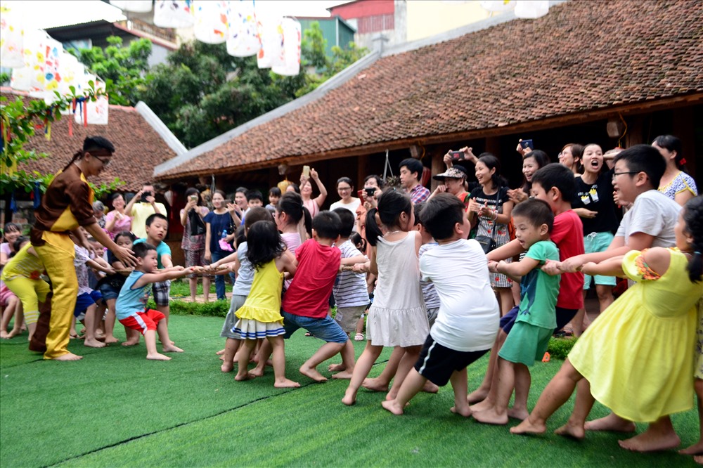Trẻ em chơi kéo co trong sân của Hồ Văn sau một thời gian dài khu vực này không hoạt động.
