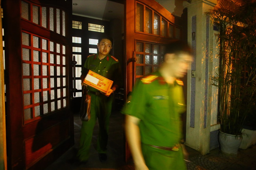 Lực lượng công an ra khỏi nhà ông Bằng sau khi khám xét xong. Trên tay cầm theo một thùng giấy được niêm phong. 