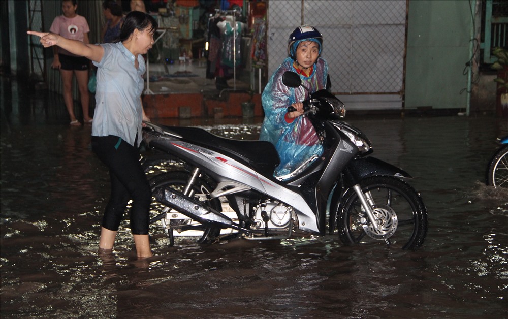 Chị Phạm Thị Dung thức tới khuya ra đẩy xe, chỉ đường, hỗ trợ những công nhân đi làm về muộn bị chết máy.