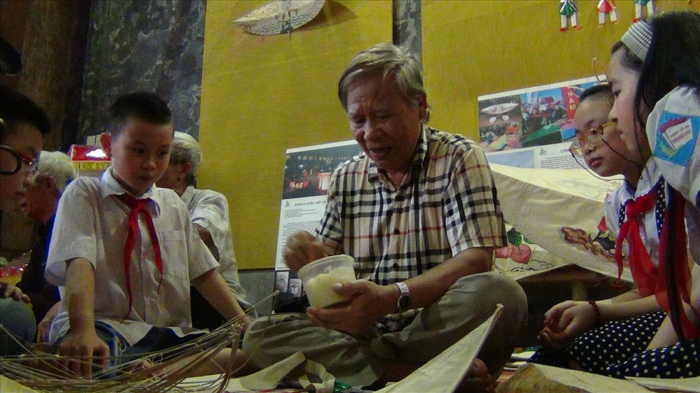 Các em học sinh hào hứng xem nghệ nhân Nguyễn Hữu Khiêm (xã Hồng Hà, Đan Phượng, Hà Nội) hướng dẫn làng diều làng Bá Giang.