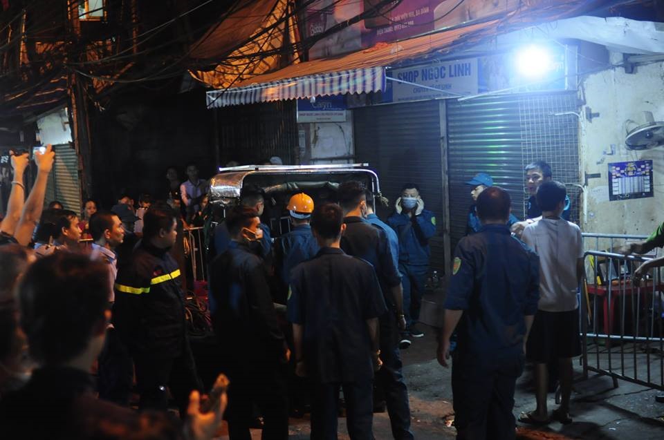 Lực lượng chức năng từng bước đưa thi thể nạn nhân ra khỏi khu vực hiện trường vụ cháy