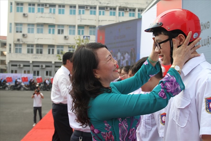 Thứ trưởng Nguyễn Thị Nghĩa trao mũ bảo hiểm cho học sinh, sinh viên. Ảnh: VC
