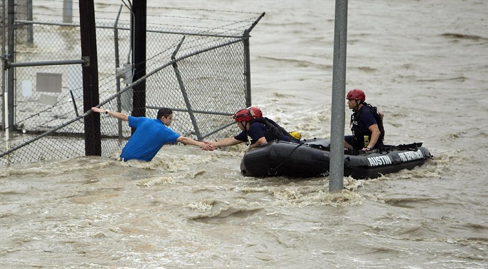 Trong bức ảnh gốc, 3 nhân viên cứu hộ của Sở cứu hỏa Austin tiếp cận một người đàn ông đang bám vào hàng rào.