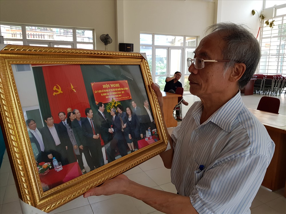 Ông Đĩnh cầm trên tay bức ảnh trong một lần ông được chụp với Chủ tịch nước Trần Đại Quang. Ảnh CN.