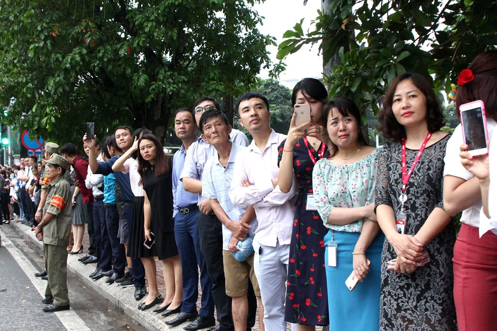 Người dân đứng hai bên đường đón chờ đoàn xe tang đi qua để tiễn biệt Chủ tịch Nước Trần Đại Quang lần cuối.