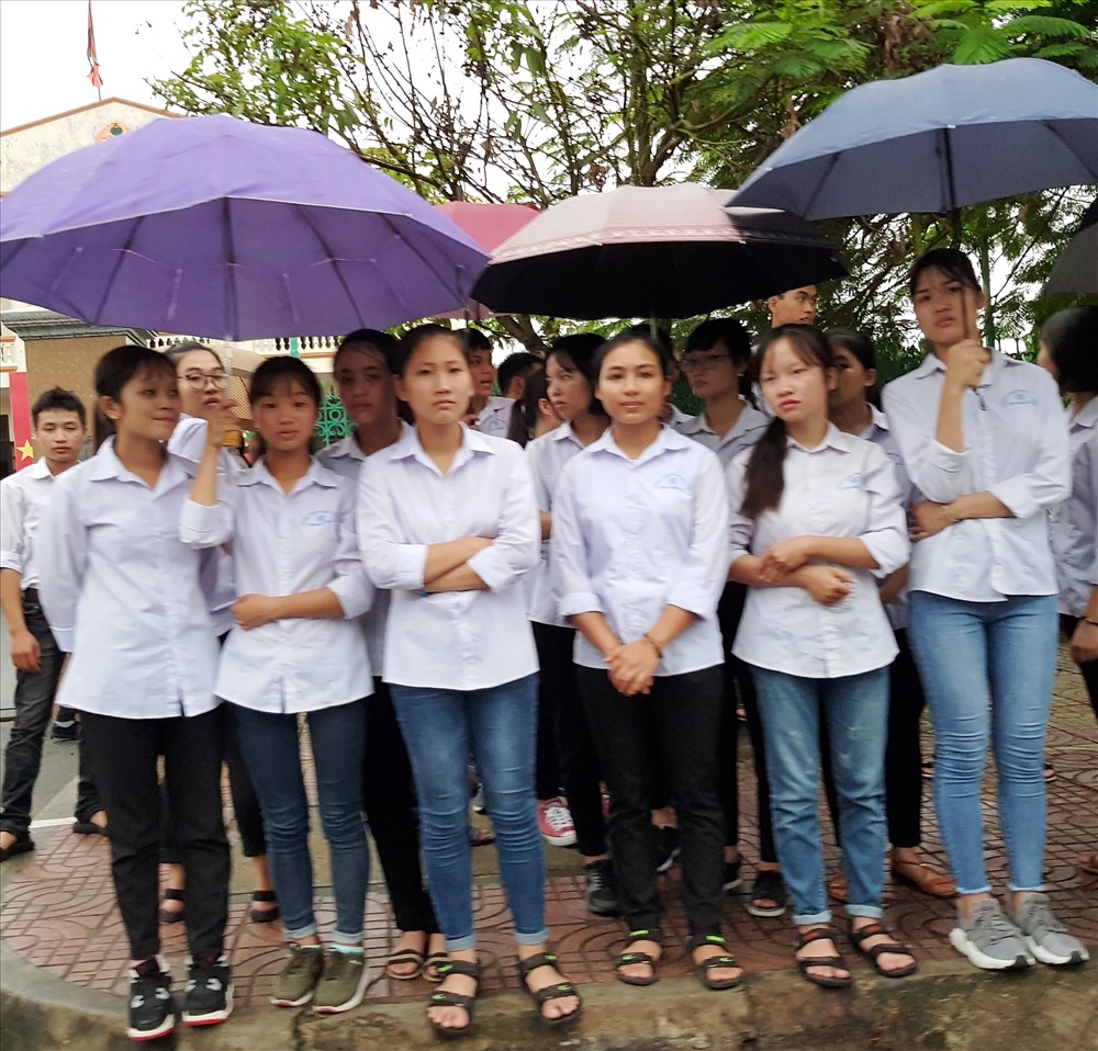 Học sinh đội mưa đón đoàn xe đưa linh cữu Chủ tịch Nước Trần Đại Quang. Ảnh: NT