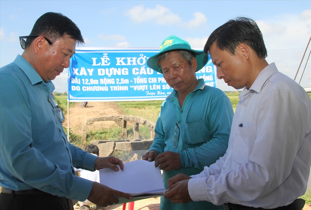 Ông Trần Anh Tuấn – đại diện chương trình “Vượt lên số phận” (trái ảnh) cùng lãnh đạo UBND xã Triệu Hòa và đơn vị thi công thống nhất phương án xây dựng cây cầu Bến Giàng. Ảnh: Hưng Thơ.