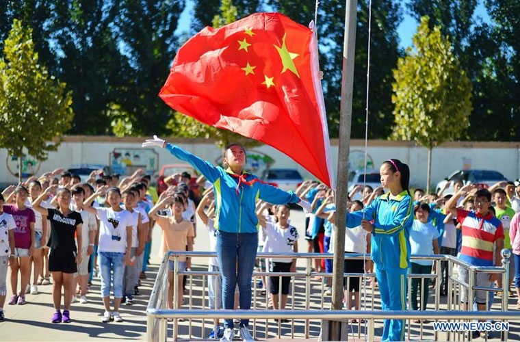 Các học sinh Trường Tiểu học Huining, Hình Đài, tỉnh Hà Bắc làm lễ chào cờ nhân ngày đầu tiên trở lại trường học sau kì nghỉ. - Ảnh: THX
